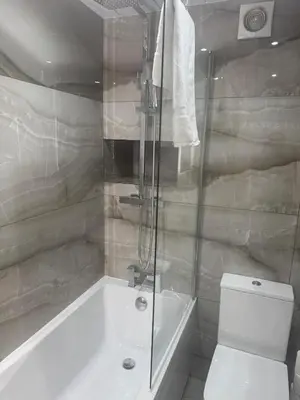 a bathroom with a tub and a toilet and a shower at Glasgow - Cosy 1 Bedroom Apartment in Glasgow