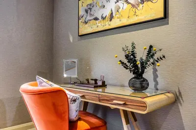 a room with a desk with a vase of flowers at Gate Lodge in Castle Douglas