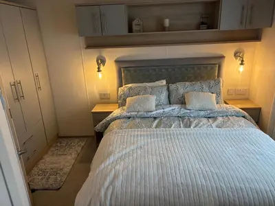 a bedroom with a large bed with two pillows at Home from Home at the Hendersons Caravan in Kilwinning