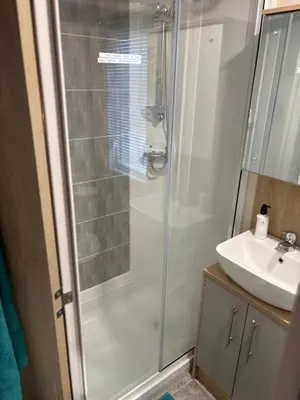 a bathroom with a shower and a sink at Home from Home at the Hendersons Caravan in Kilwinning