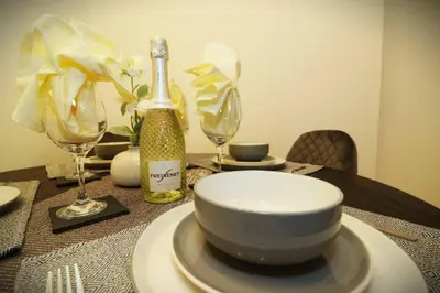 a table with a bowl and a bottle of wine at Modern 3BR Home with Parking in East Kilbride