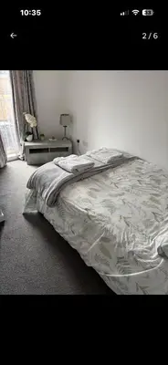 a bedroom with a bed and a table and a window at Room in shared flat in Edinburgh