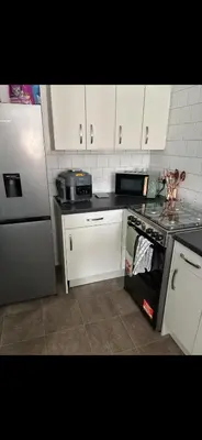 a kitchen with white cabinets and a stove top oven at Room in shared flat in Edinburgh