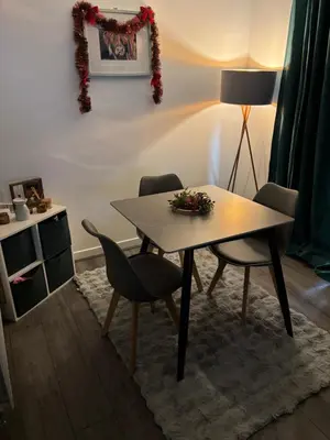 a table and chairs in a living room with a lamp at Room in shared flat in Edinburgh