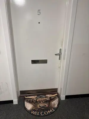 a dog bed in front of a white door at Room in shared flat in Edinburgh