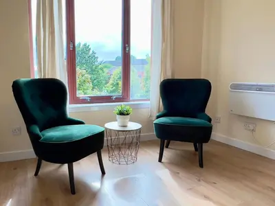 two chairs and a table in a room with a window at Garden-View 2BR Apartment - Free Parking & WiFi in Glasgow