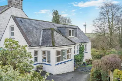 an exterior view of a white house with a roof at 3 Bed in New Galloway oc-r34387 in New Galloway