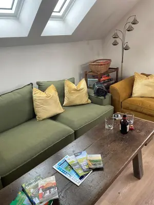 a living room with a green couch and a coffee table at West Coast Whistlestop in Ochiltree