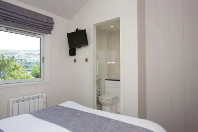 a white bedroom with a toilet and a window at Ardeonaig Rock in Morenish