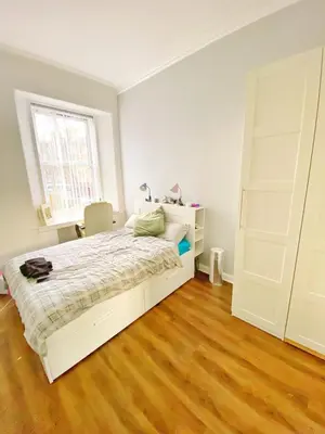 a bedroom with a white bed and a wooden floor at Two-bedroom city retreat close to top sites in Edinburgh