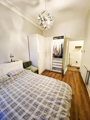 a bedroom with a bed and a closet and a chandelier at Two-bedroom city retreat close to top sites in Edinburgh
