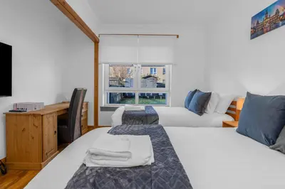 a bedroom with two beds and a window at Executive 3 Bedroom - Corporate And Contractor Stays in Glasgow