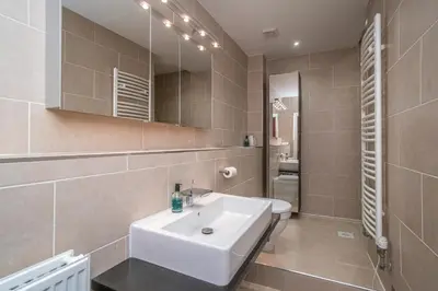 a bathroom with a white sink and a mirror at Georgian Elegance with Patio Garden West End - Pass the Keys in Edinburgh