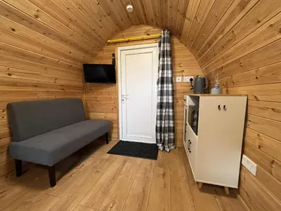 a room with a chair and a door in a cabin at Pentland View Campsite in Haywood