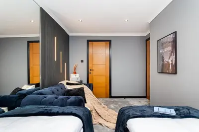 a room with four blue couches in front of a door at The Apartment in Paisley