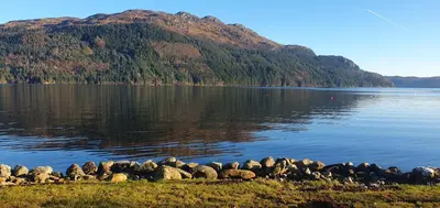 a large body of water with a mountain in the background at Carrick Chalets in Cairndow