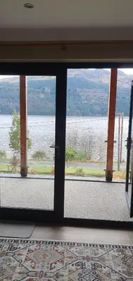 a view of the water from a glass door at Carrick Chalets in Cairndow