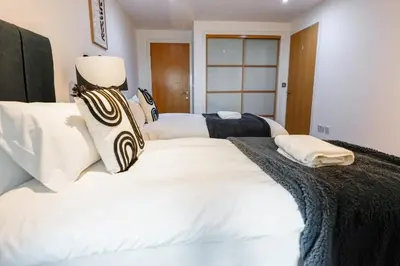 a bedroom with two beds with white sheets at The Lancefield Luxe in Glasgow