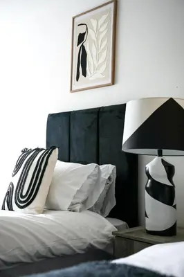 a bedroom with a bed with a black headboard and a lamp at The Lancefield Luxe in Glasgow
