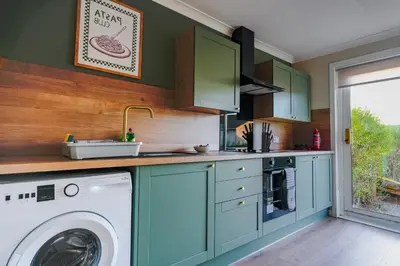 a kitchen with a washer and a washing machine at Cruachan House in Falkirk