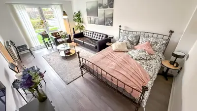 a bedroom with a bed and a living room at New Modern Detached House with 5bdr Glasgow in Renfrew
