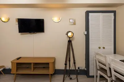 a room with a television and a table and a tripod at Charming and Spacious City Getaway 3 in Edinburgh