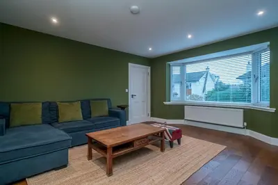 a living room with a blue couch and a table at Spacious 5-Bed Home with Garden Parking - Pass the Keys in Edinburgh