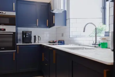 a kitchen with blue cabinets and a sink at Old Kirk Apartment in Oban