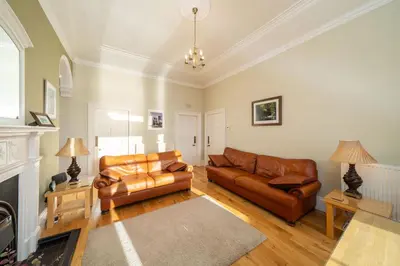 a living room with two leather couches and a fireplace at Cleish Apartment in Edinburgh