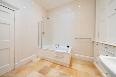 a bathroom with a shower and a tub and a sink at Cleish Apartment in Edinburgh