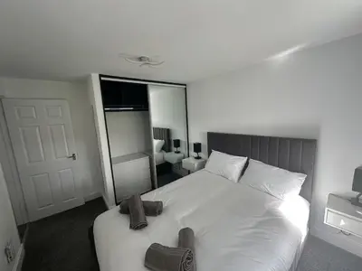 a bedroom with a white bed with towels on it at Family - Garden - Parking - WiFi - Sleeps 5 in Tullibody