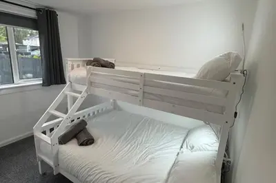 a bedroom with two bunk beds and a window at Family - Garden - Parking - WiFi - Sleeps 5 in Tullibody
