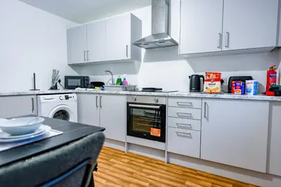 a kitchen with white cabinets and a stove top oven at Sedgebank House in Livingston
