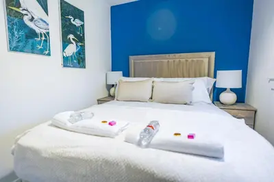 a bedroom with a white bed with a blue wall at Sedgebank House in Livingston