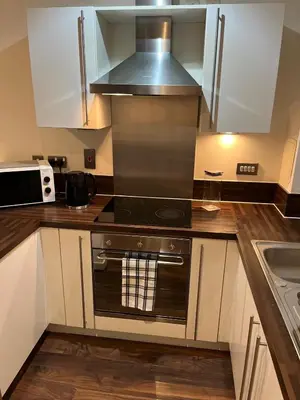 a kitchen with white cabinets and a stove top oven at City centre luxury apartment in Glasgow