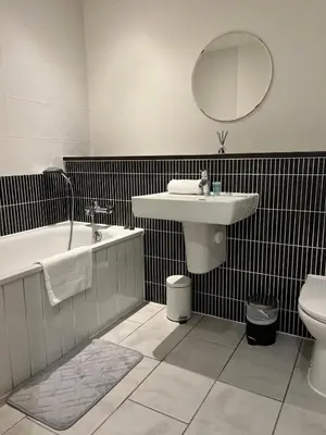 a bathroom with a sink and a tub and a toilet at City centre luxury apartment in Glasgow