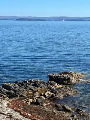 a view of a large body of water with rocks at The Corrie Hotel in Corrie