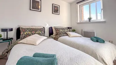 two twin beds in a room with a window at Wonderfull stays new property near Glasgow 2 bedrooms in Dalmuir