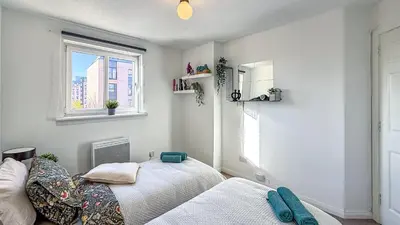 a bedroom with two beds and a window at Wonderfull stays new property near Glasgow 2 bedrooms in Dalmuir