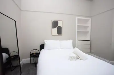 a bedroom with a white bed and shelves at Stylish Southside 2 Bedroom Flat with Free Parking in Glasgow