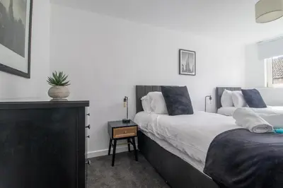 a bedroom with two beds and a dresser in it at The Kings Height close to Glasgow and Edinburgh in Airdrie