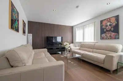 a living room with a white couch and a television at The Kings Height close to Glasgow and Edinburgh in Airdrie