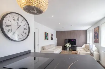 a living room with a large clock on the wall at The Kings Height close to Glasgow and Edinburgh in Airdrie