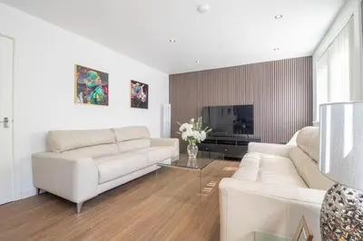 a living room with white couches and a tv at The Kings Height close to Glasgow and Edinburgh in Airdrie
