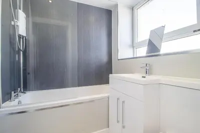 a white bathroom with a sink and a window at The Kings Height close to Glasgow and Edinburgh in Airdrie