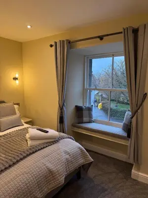 a bedroom with a window with a bed and a window seat at Corner House, newly refurbished, Dunning in Dunning