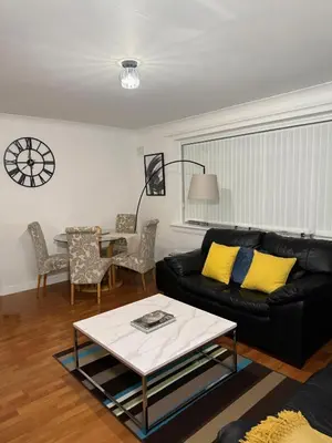 a living room with a black couch and a table at The Telford Nook in Edinburgh