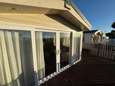 a porch with sliding glass doors on a house at Turnberry Holiday Park Amazing Sea View in Girvan