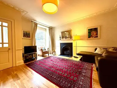 a living room with a red rug on the floor at Cozy 1 bed Garden flat in the New Town City Centre in Edinburgh