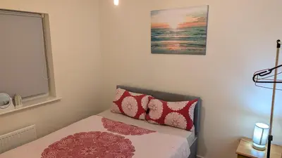 a bedroom with a bed with two pillows on it at NG Property in Glasgow